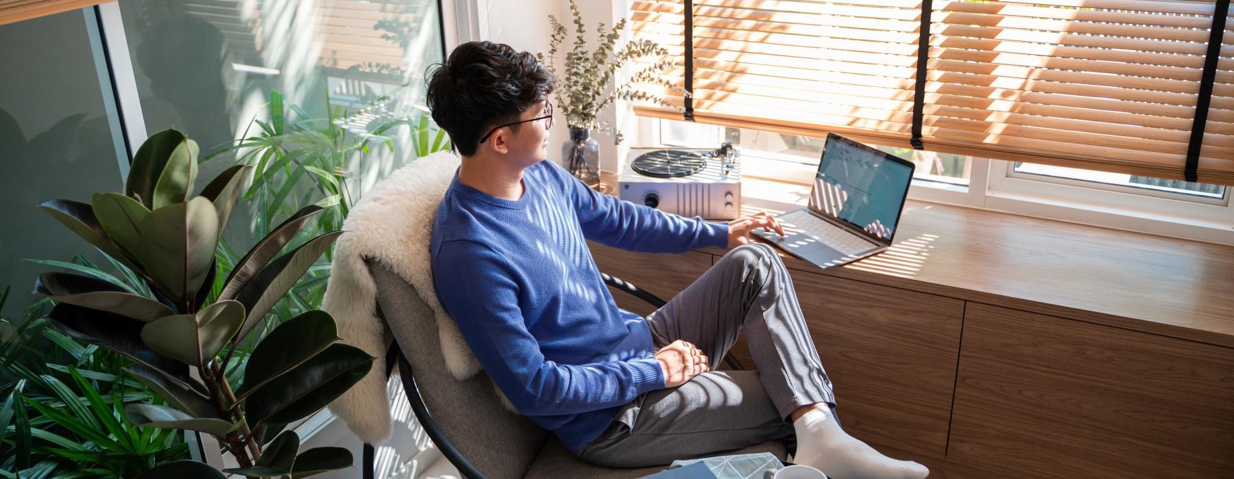 a person sitting in a chair with a laptop